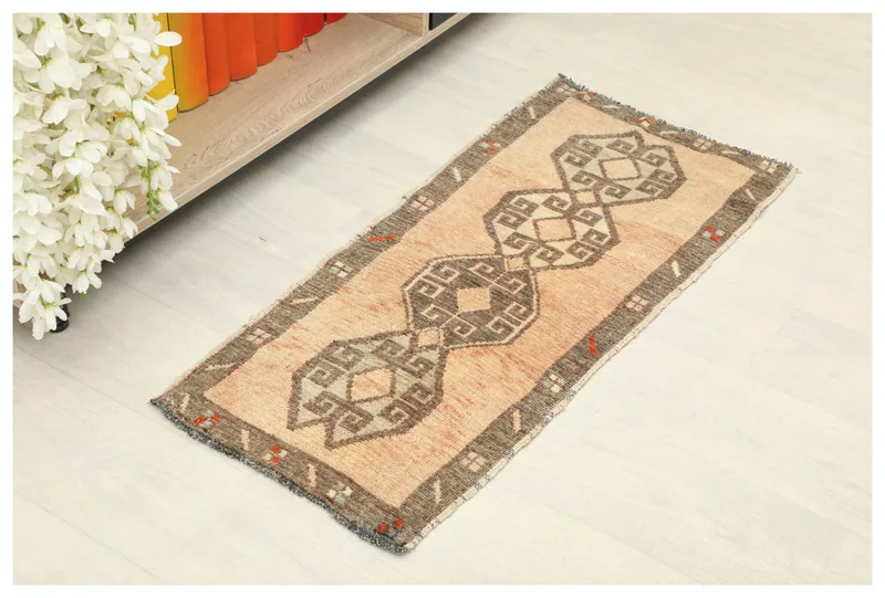Full top view of the vintage orange geometric Anatolian rug on a white background.
