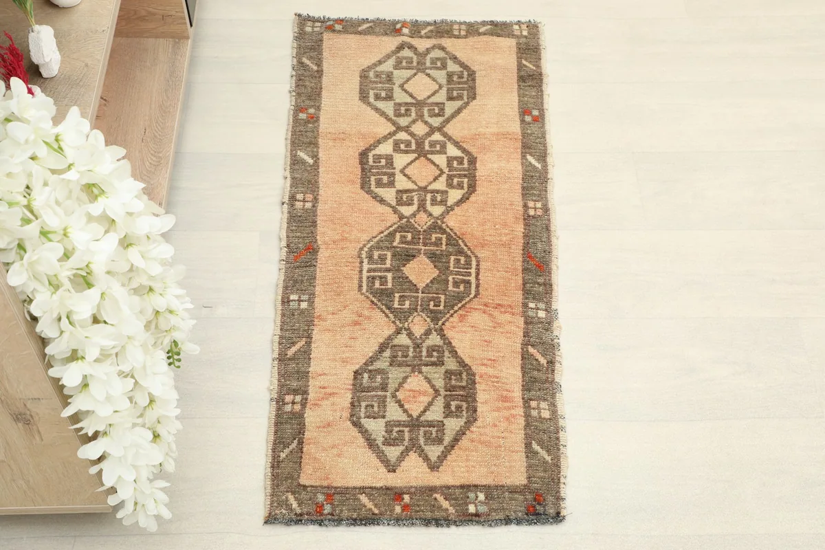 Overhead view of the orange rug, showcasing its central geometric design and charcoal border.