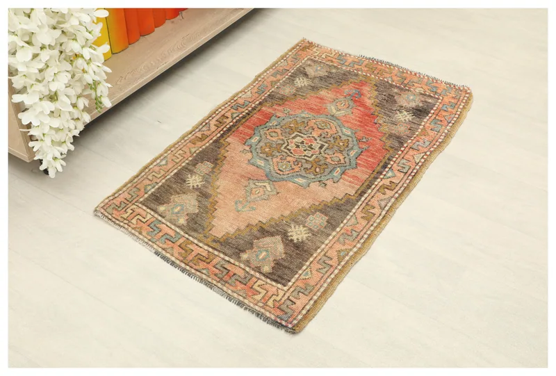 Full overhead view of the 1'10" x 3'2" vintage Anatolian doormat on a white background