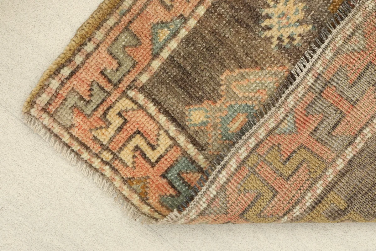 View of the rug folded to show the thickness and texture of the vintage wool pile