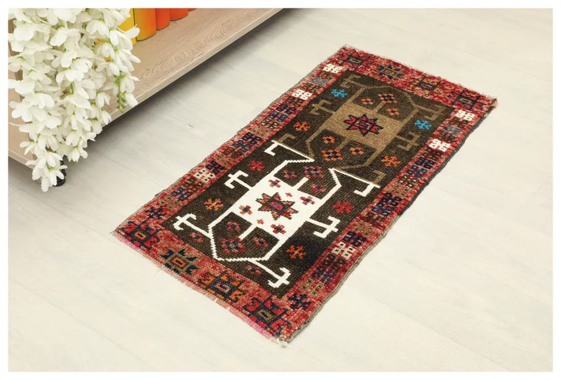 Full overhead view of the 1'3" x 2'9" brown and red vintage Anatolian doormat on a white background.