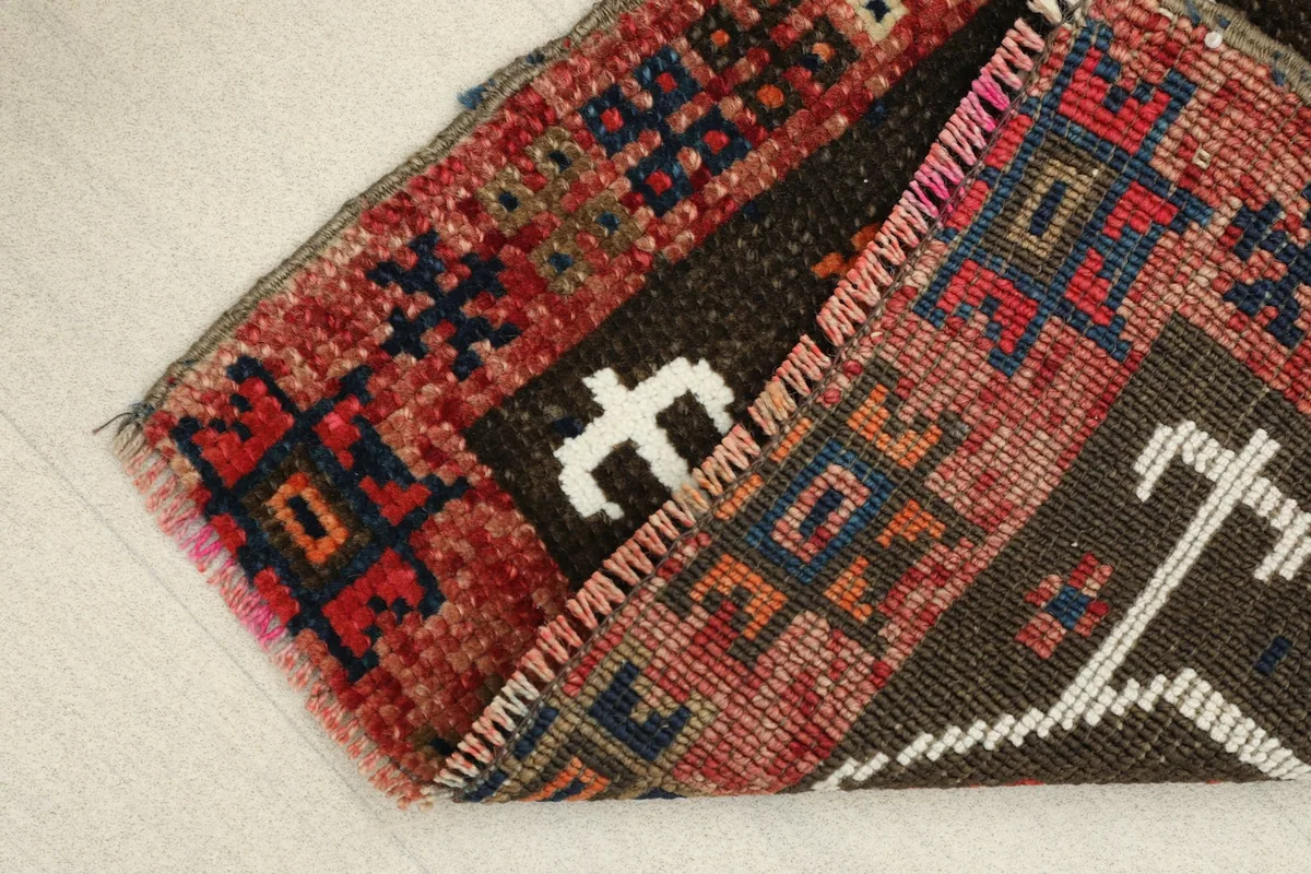 View of the rug folded to show the thickness of the wool pile and the cotton foundation.