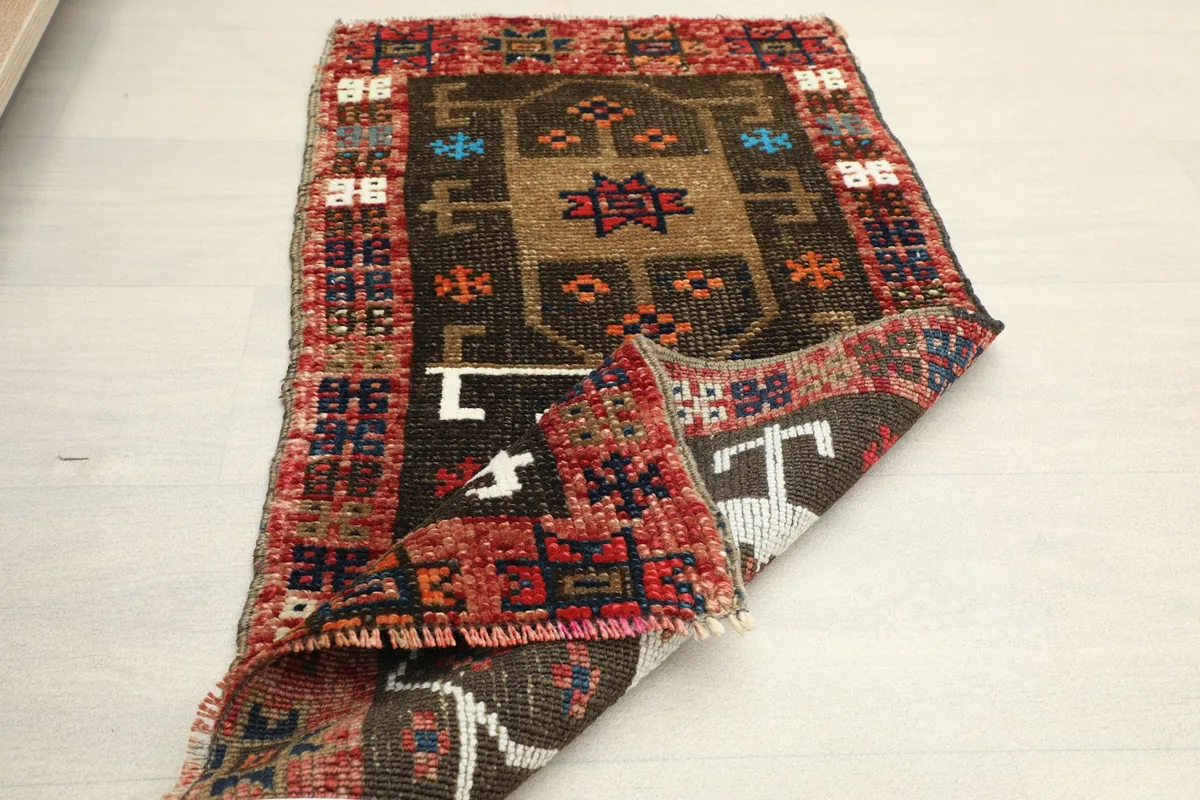 The doormat partially folded, illustrating the flexibility and construction of the vintage piece.