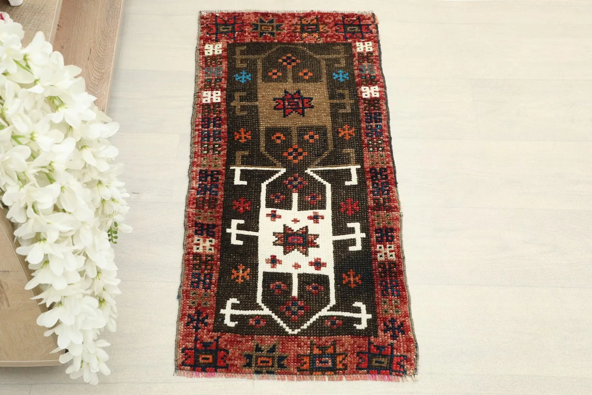 Straight overhead view of the hand-knotted brown and red tribal doormat, showing its full design.