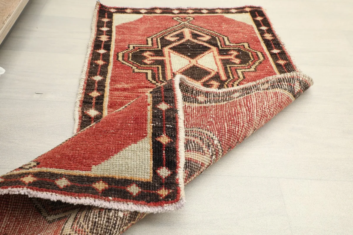 Angled view of the rug, partially folded, displaying the back and front textures.