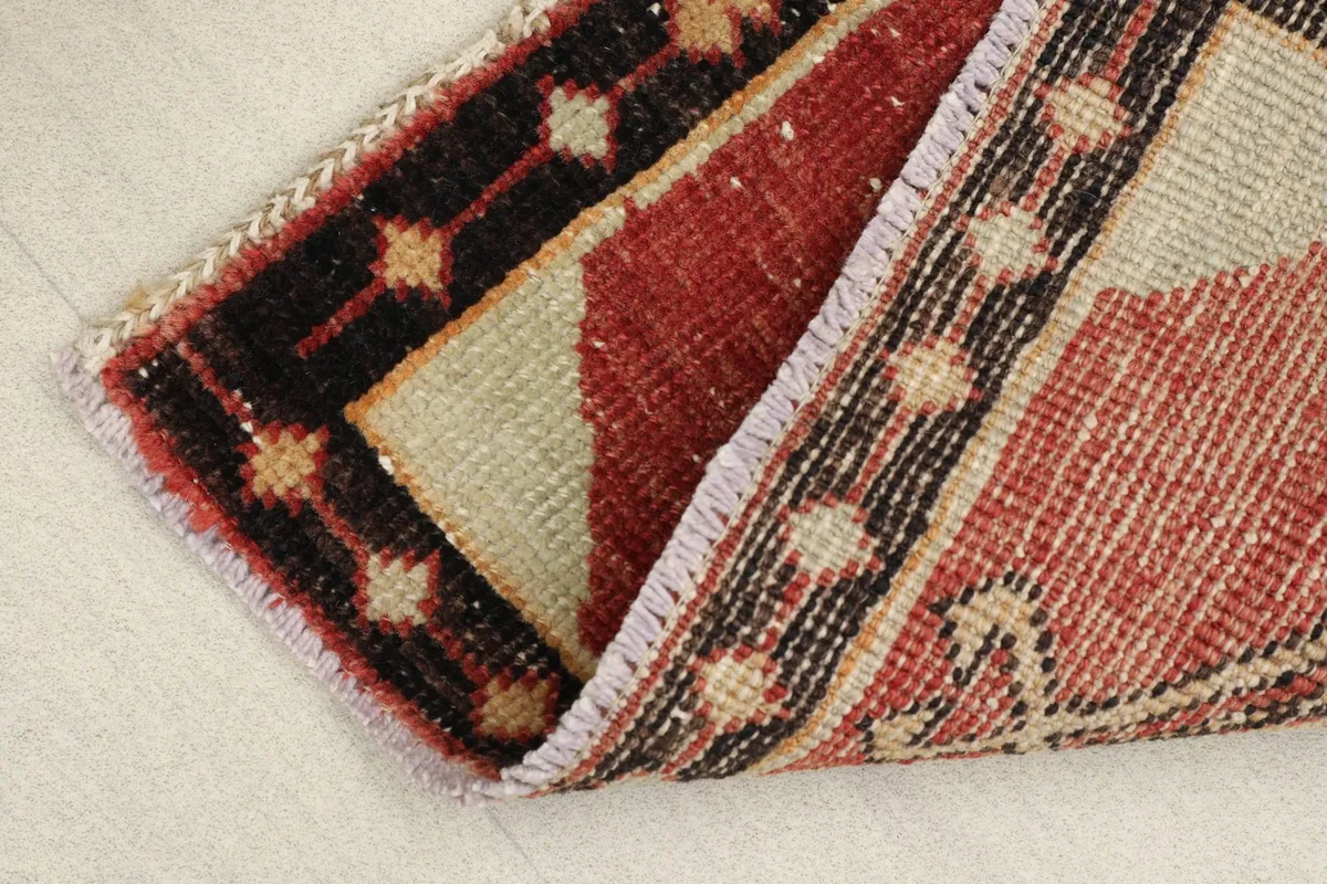 View of the rug folded to show the thickness of the wool pile and cotton foundation.