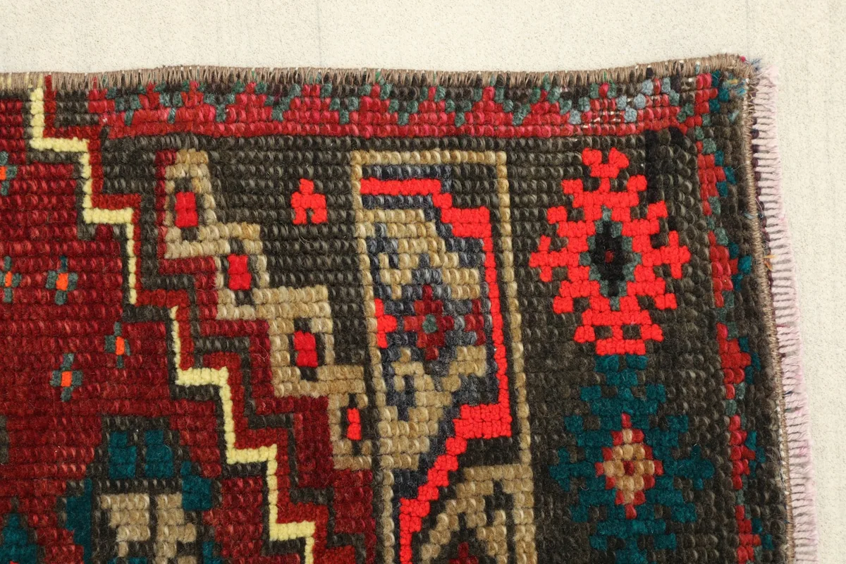 Close-up of the geometric motifs and color variations within the rug's pattern.