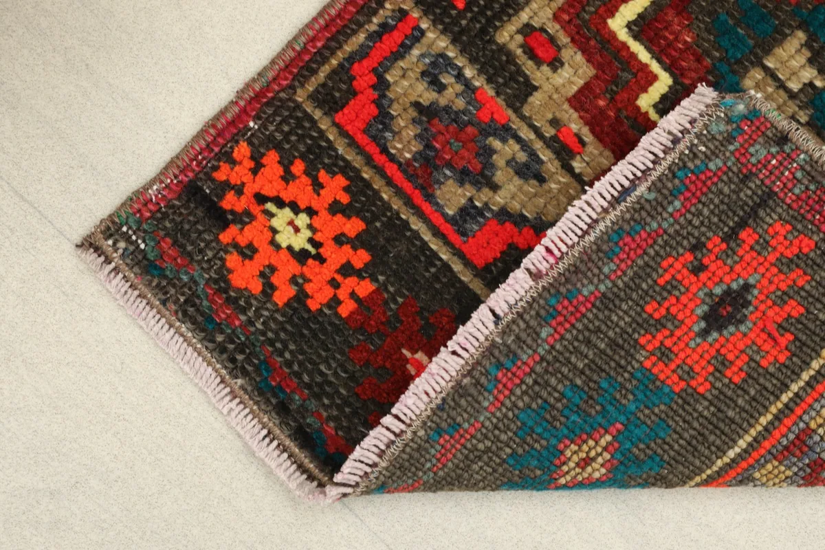 View of the rug folded, showing the thickness of the wool pile and cotton foundation.