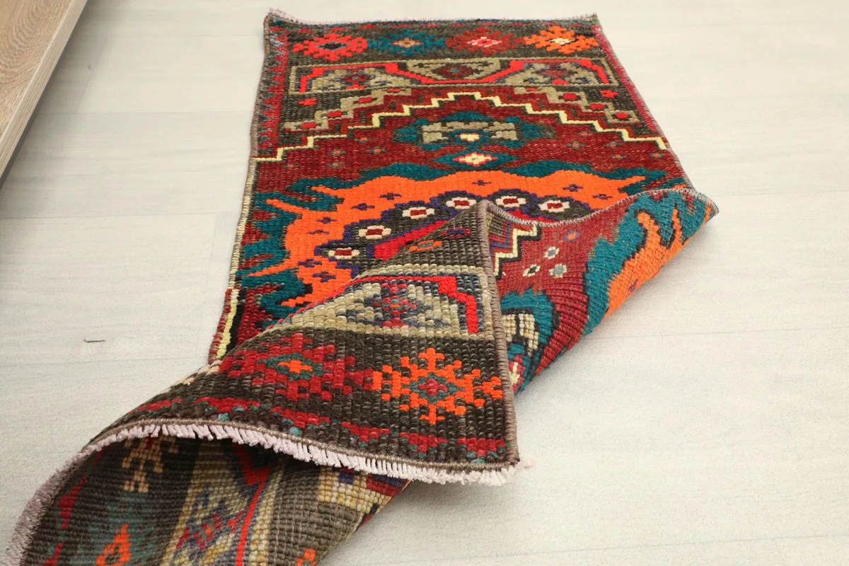 The rug partially folded to show its flexibility and the reverse side.
