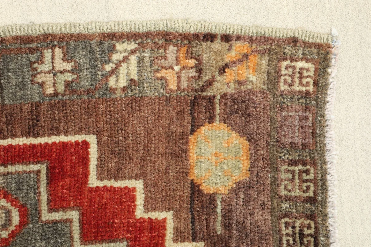 Close-up of the rug's edge, revealing the hand-knotted pile and border designs