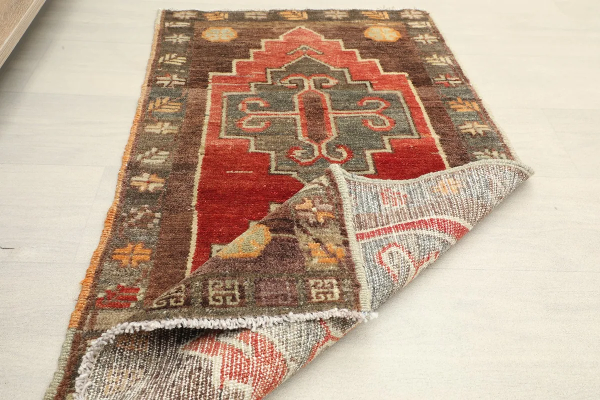 Partial view of the rug with a corner folded back, displaying the reverse side
