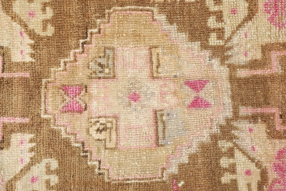 Tight detail shot of the central medallion design, highlighting the wool pile and colors.
