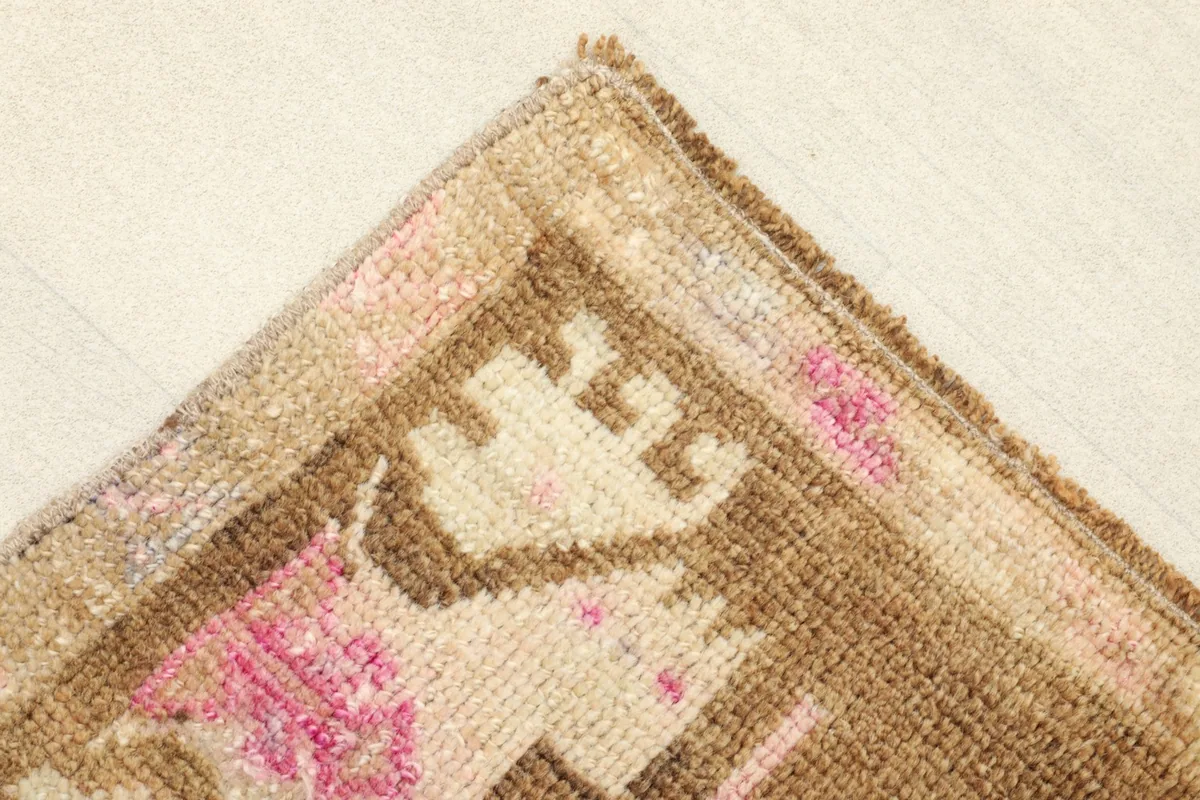 Corner detail of the rug, showing the border pattern and the character of the vintage weave.