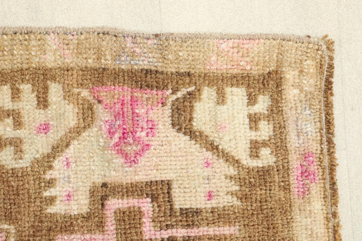 Side border detail of the rug, displaying the geometric elements and color variations.
