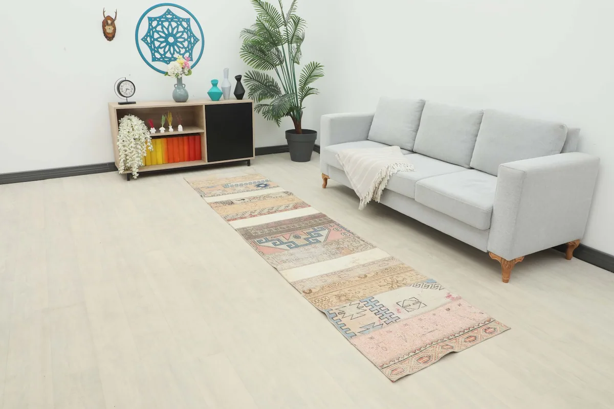 Runner extending from a modern sofa into a room with light flooring and decor