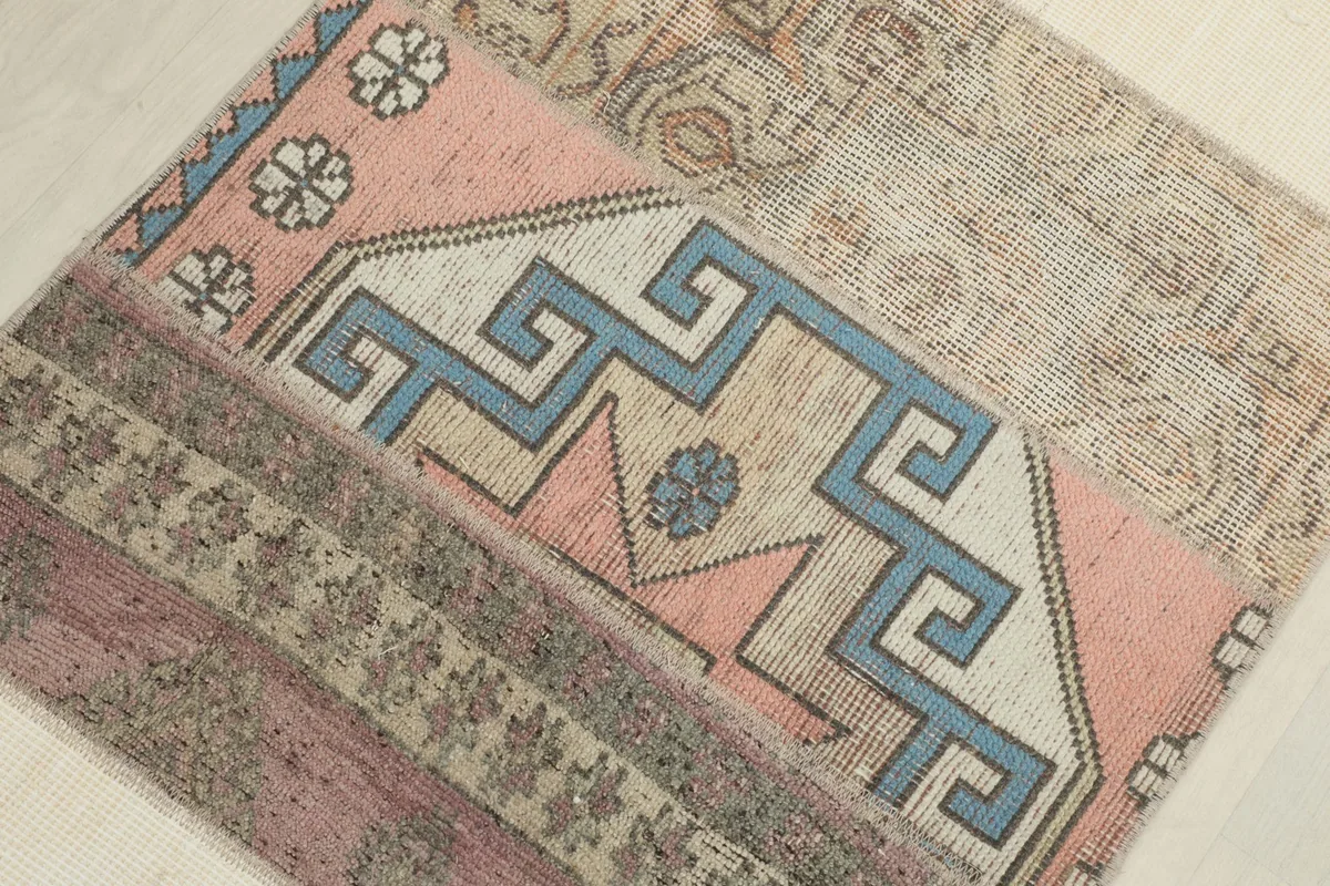 Overhead close-up of rose and blue geometric motifs within the patchwork design