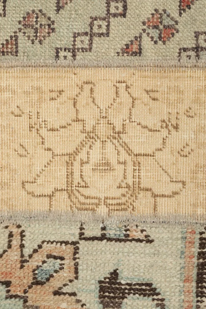 Detailed shot of a beige panel with a subtle stylized floral motif and blue patterns