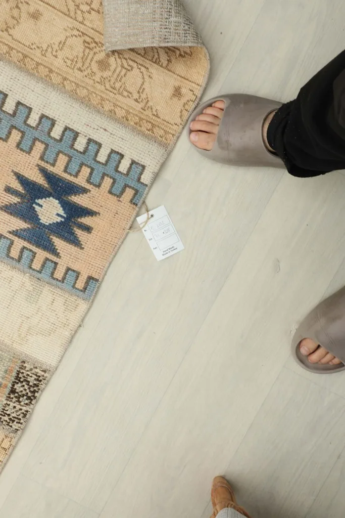 Top-down view of a person's feet next to the runner, showing its scale and texture