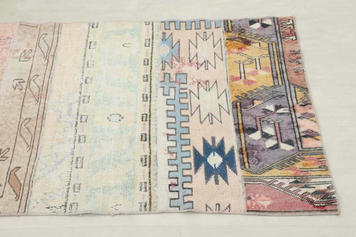 Close-up view of the runner's end section, showing geometric patterns in blue, purple, and gold