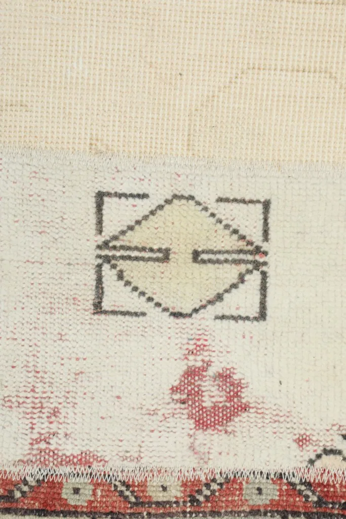 Close-up showing the back of the rug, revealing the hand-knotted cotton foundation and wool pile