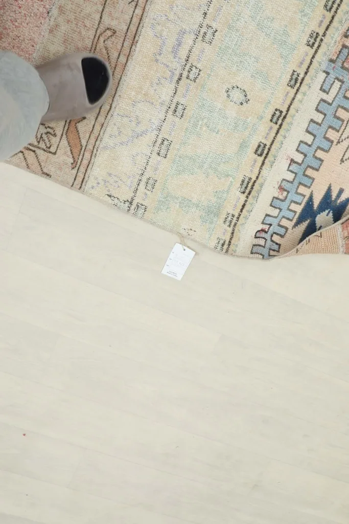 Overhead view showing the rug's label and part of the cotton foundation next to the patterned pile