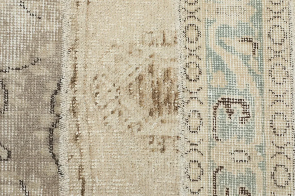 Close-up of a patch with abstract brown and gray motifs, showcasing the vintage patina.