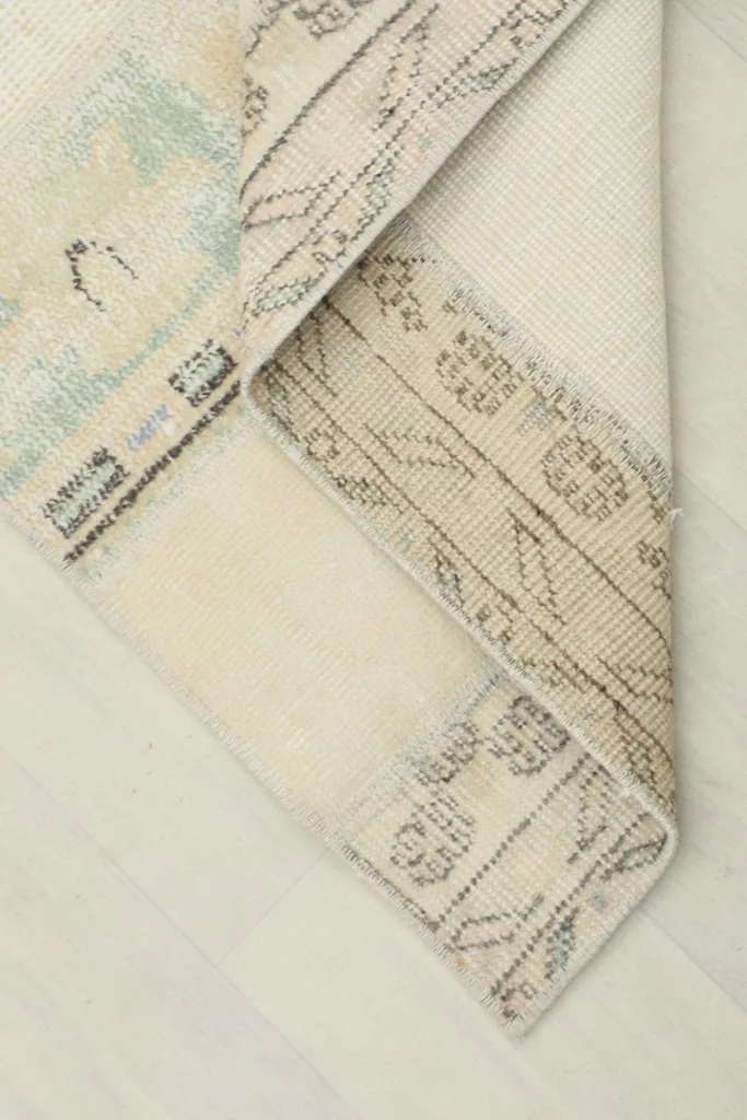 Corner of the runner folded to reveal the cotton foundation and the reverse side of the hand-knotting.