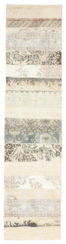 Full overhead view of the ivory and blue patchwork vintage runner rug on a white background
