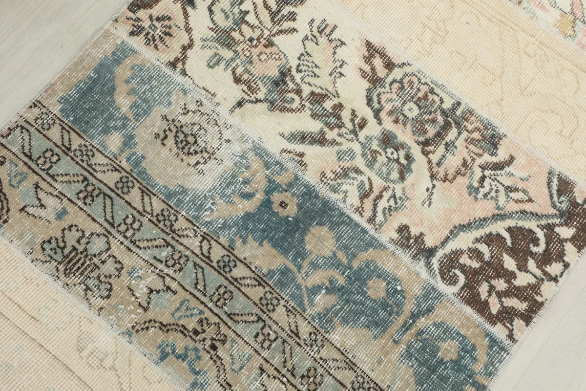 Macro view highlighting the intricate floral and geometric motifs in blue, brown, and ivory patches