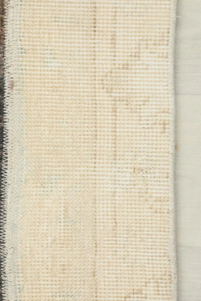 View of the rug's cotton foundation and the hand-knotted construction from the reverse side
