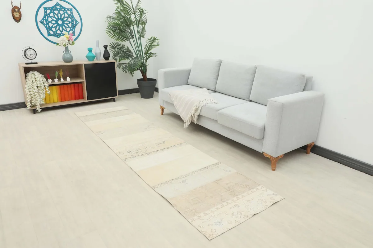Long view of the cream and beige runner rug in a modern living space with a light sofa