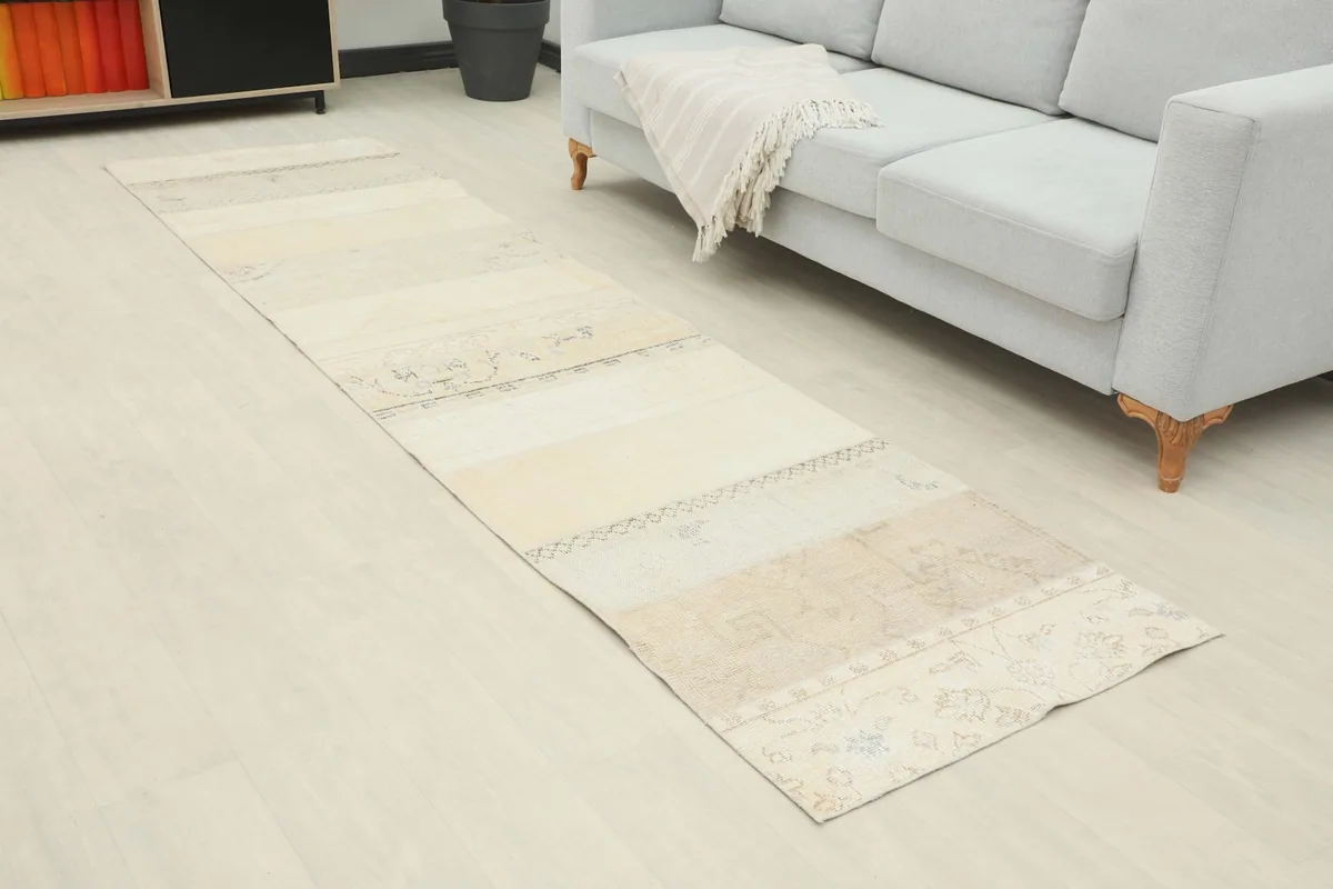 Angle view of the runner rug extending along a light-colored floor next to a sofa
