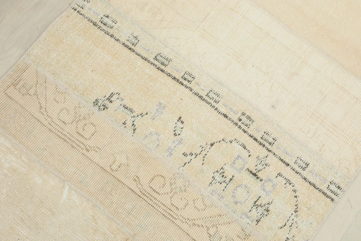 Detailed view of a light beige section with very faint blue and gray floral patterns