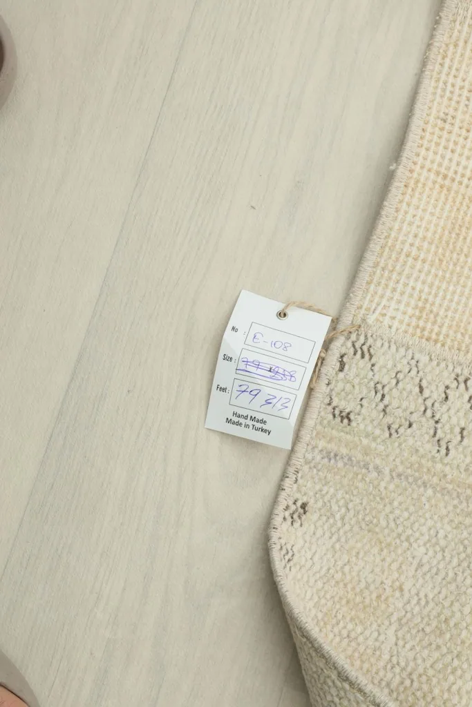 Product tag attached to the vintage runner rug, showing size and origin details