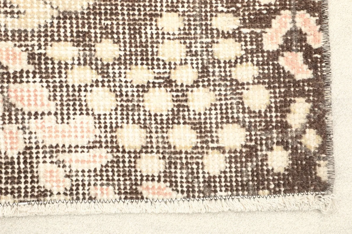Close-up detail of the brown border with dotted patterns and rose and beige motifs