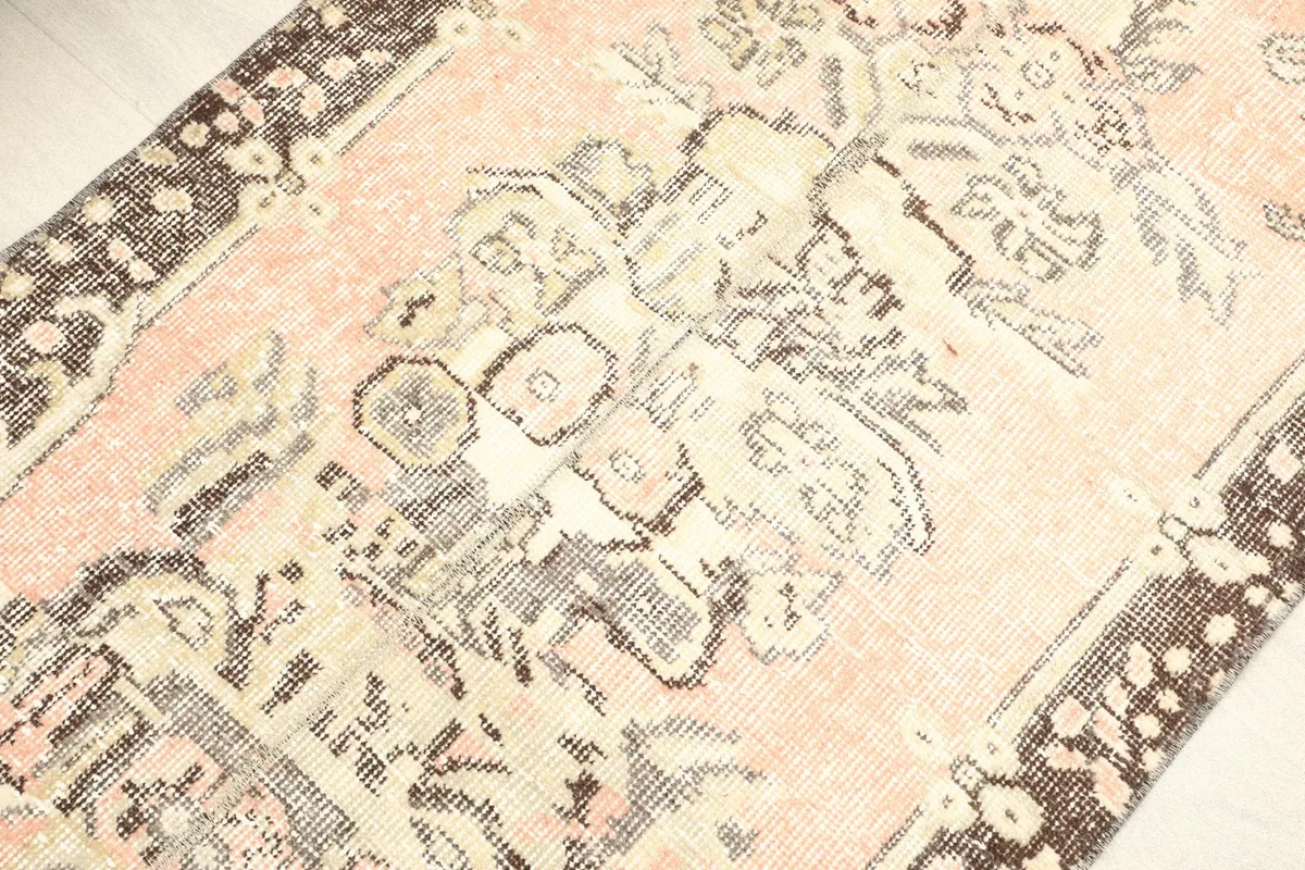 Detailed view of the central rose field with faded floral and geometric patterns in beige and gray