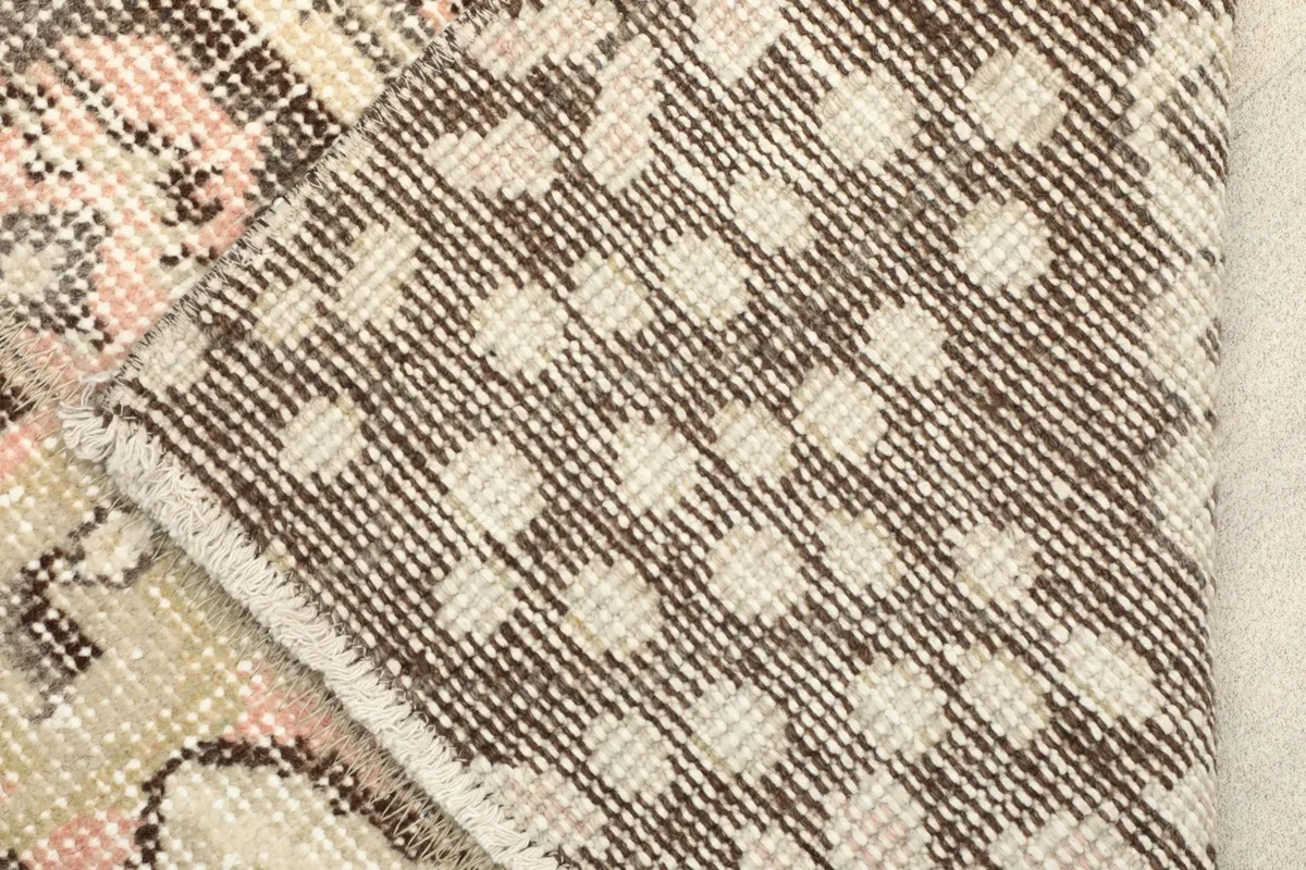 View of the back of the hand-knotted wool rug, showing the cotton foundation