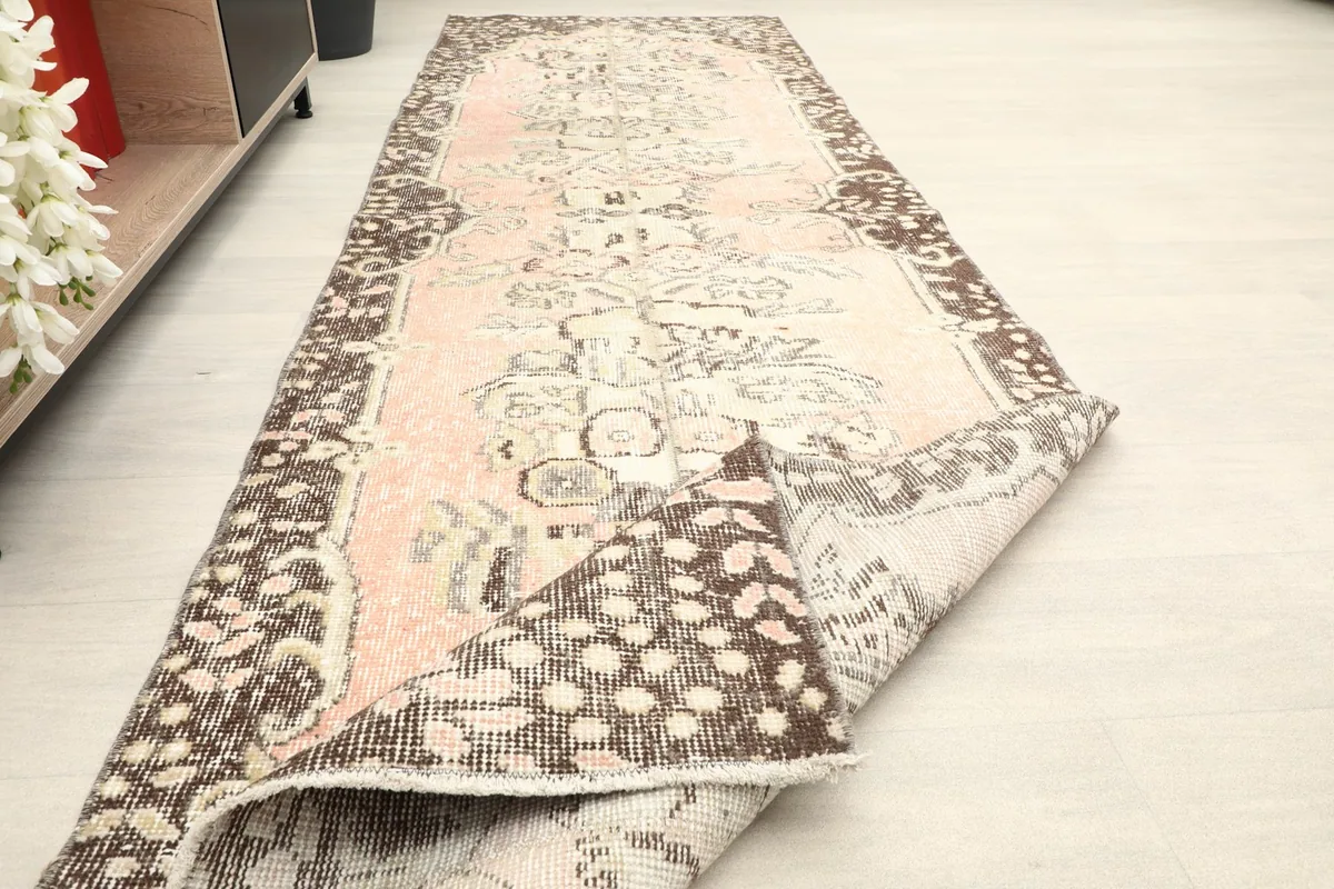 The runner partially folded, revealing the reverse side and flexibility of the vintage wool