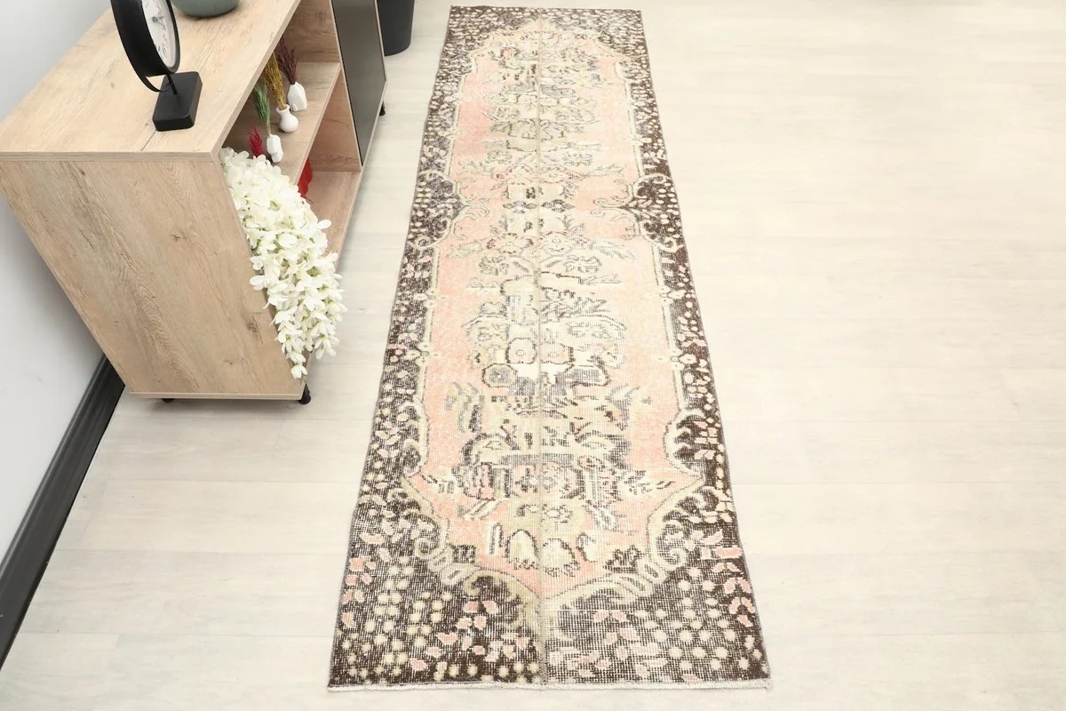 Overhead view of the rose and brown vintage runner rug, showcasing its full pattern
