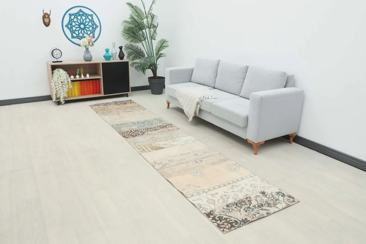 Long runner rug in a room setting next to a gray sofa, showing its full length