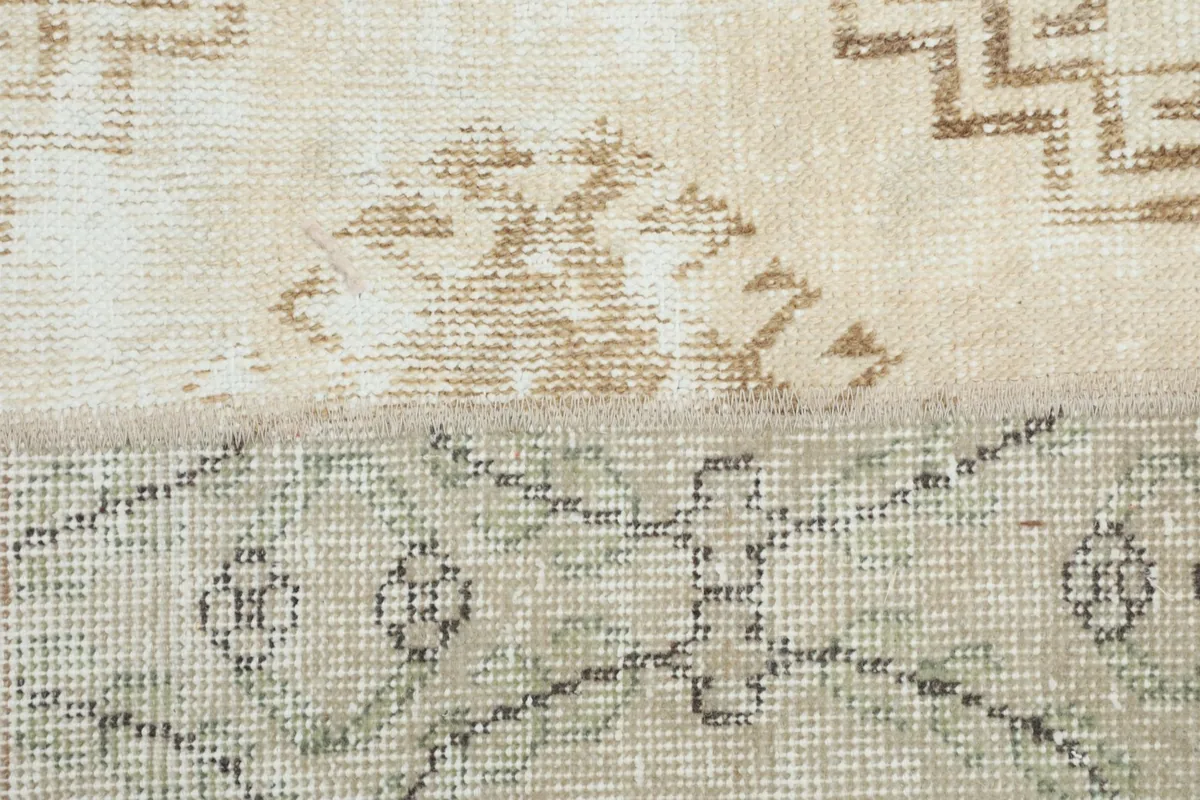 Close-up showing the weave and texture of two different beige and tan rug patches