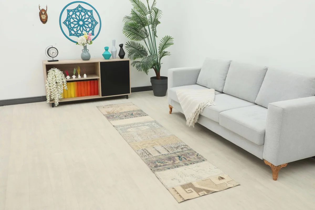 Vintage patchwork runner rug displayed in a modern living room setting with a light sofa.