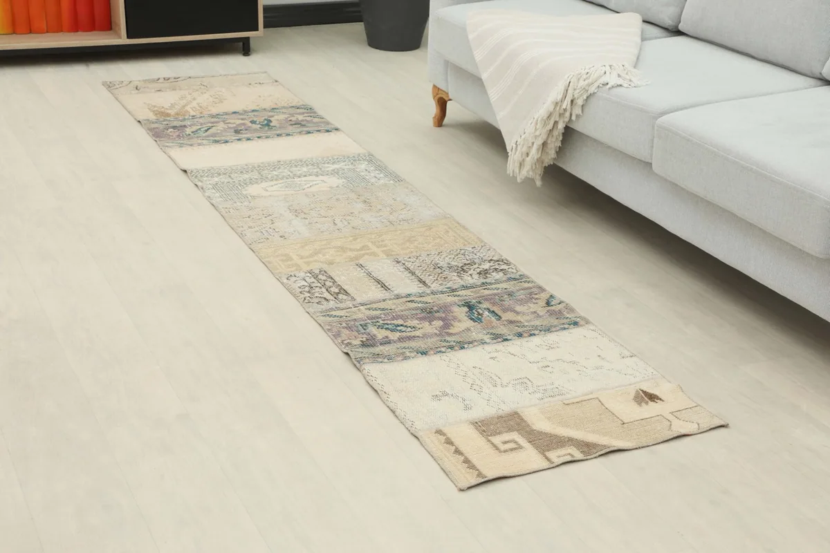 Angle view of the Anatolian runner rug extending along a light-colored floor next to a sofa.