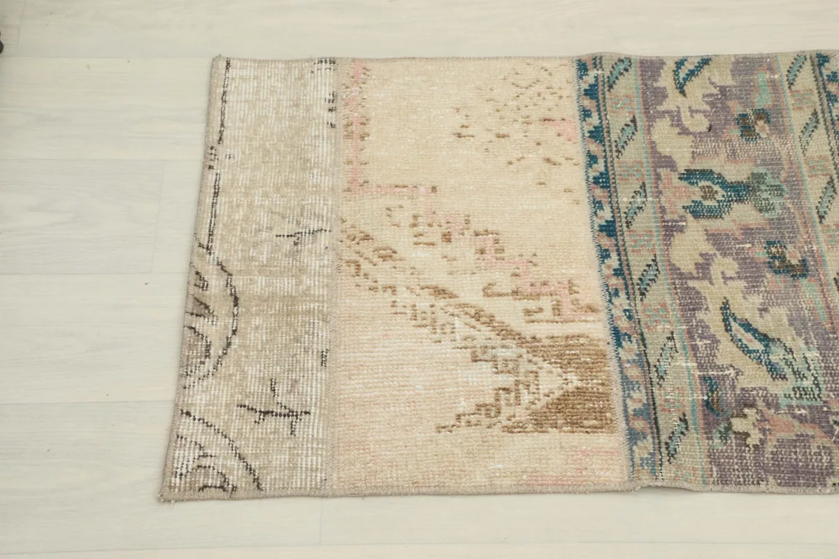Close-up of two patched sections, one with faded beige and tan tones, the other with purple and blue motifs.