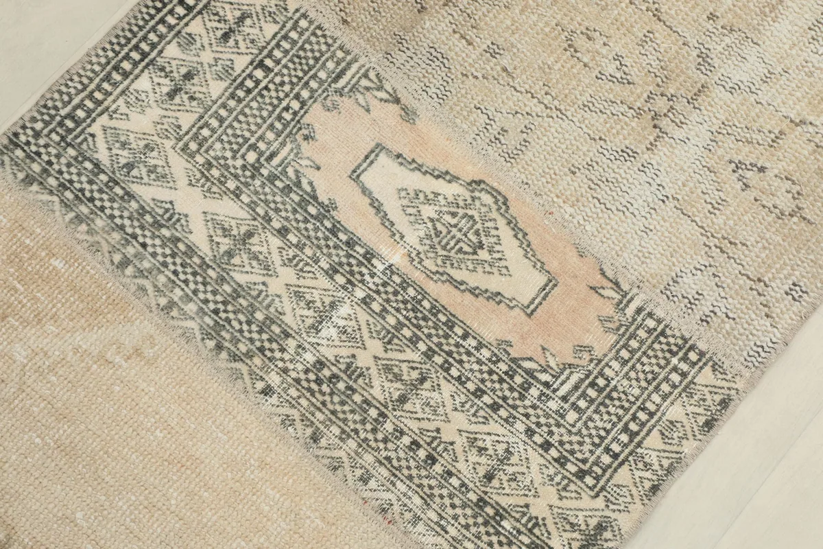 Overhead detail view of a beige and gray geometric patterned patch within the runner.
