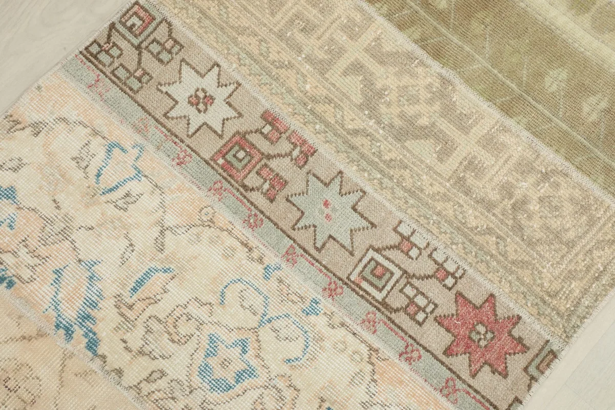 Detailed view of geometric patterns in beige, red, and light blue within the patchwork runner