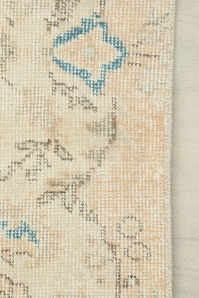 Texture of the low wool pile on a beige section with subtle blue and brown patterns