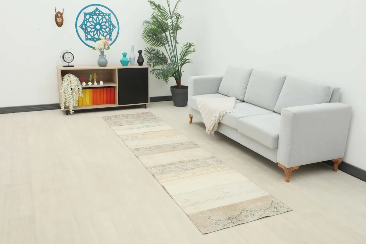 Vintage runner rug in an entryway with a light gray sofa and modern decor