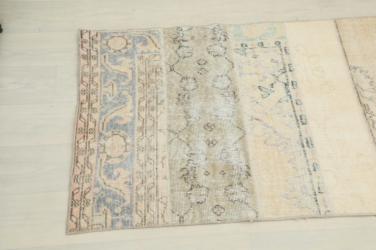 Close-up of a section of the runner rug showing gray and tan patches with faded motifs