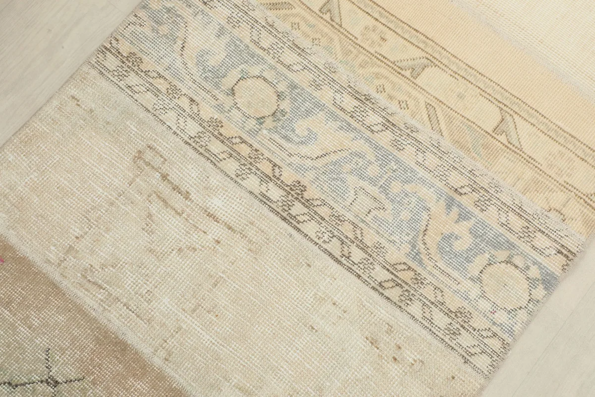 Detail of the rug's surface, highlighting the blend of ivory, beige, and light blue-gray tones